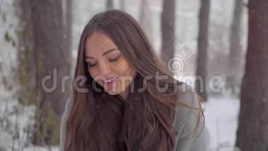 美丽的年轻女子在冬天的公园里喂松鼠。 笑脸的特写.. 慢动作。 她冬天很快乐